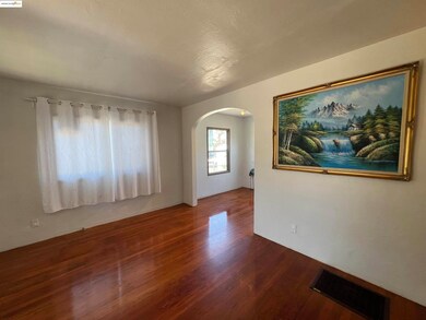 Spare room with arched walkways and wood finished floors