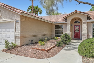 View of exterior entry with a tile roof, stucco si