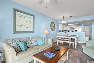Living room featuring ceiling fan, dark hardwood /