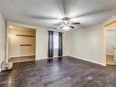 Empty room with dark hardwood / wood-style floors, ceiling fan, and a textured ceiling