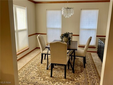 Dining room featuring light carpet, crown molding, and a chandelier