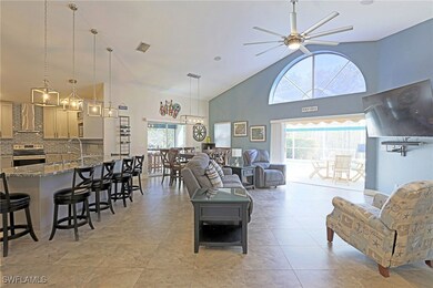 Tiled living room featuring sink, high vaulted cei