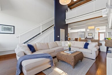 Living area with wood finished floors, a towering