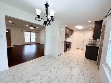 Kitchen featuring decorative light fixtures, appliances with stainless steel finishes, and light tile flooring