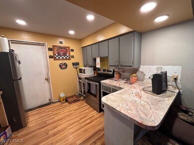 Kitchen featuring gray cabinetry, stainless steel