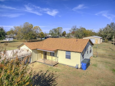 View of front of property featuring a shingled roof and a porch