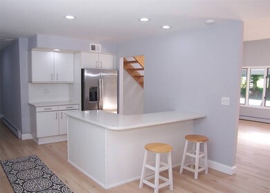Kitchen featuring stainless steel fridge, light wood finished floors, a baseboard heating unit, and recessed lighting