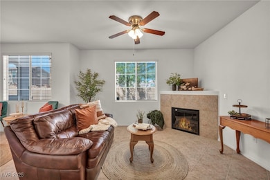 Living room with a ceiling fan, a tiled fireplace,