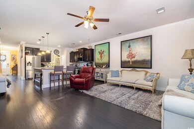 Living room featuring ceiling fan, ornamental mold