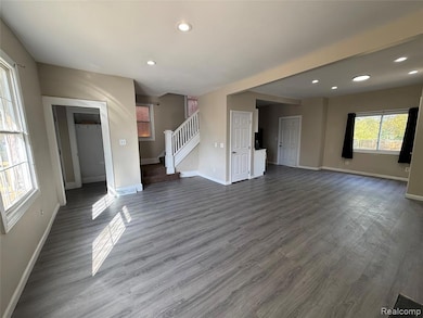 Unfurnished living room featuring recessed lighting, wood finished floors, and stairway