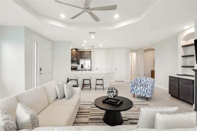 Living room featuring ceiling fan and a tray ceili
