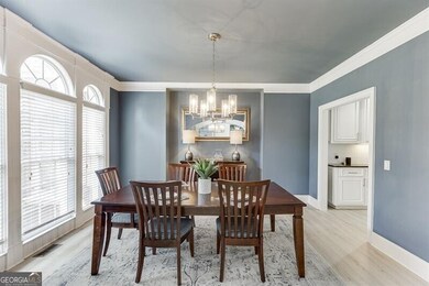 Dining area with a chandelier, light wood finished floors, and crown molding