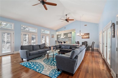 Living room featuring french doors, a ceiling fan, hardwood / wood-style flooring, and high vaulted ceiling