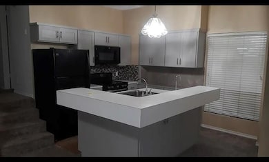 Kitchen featuring black appliances, a sink, backs