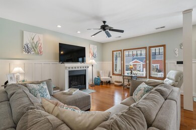 Living room featuring ceiling fan, wainscoting, a 