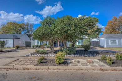 View of property hidden behind natural elements featuring a porch