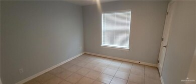 Unfurnished room with light tile patterned floors and baseboards
