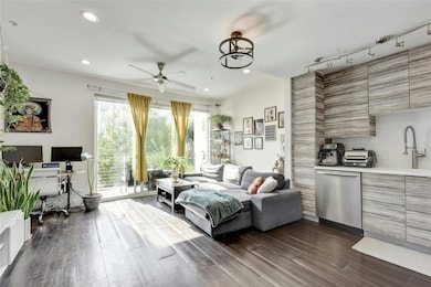 Living room featuring dark wood-style floors, tra