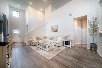 Living area featuring a high ceiling, baseboards,