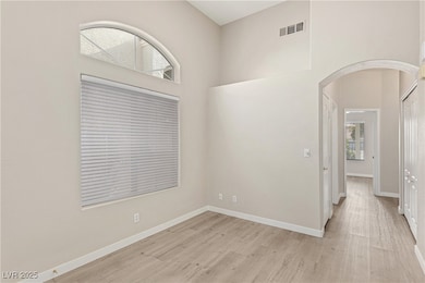Unfurnished room featuring arched walkways and light wood finished floors
