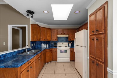 Kitchen with white appliances, backsplash, light t