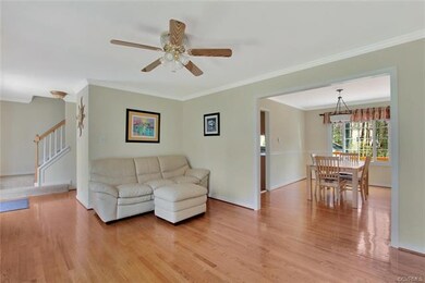 Family room with wood floor, ceiling fan, crown mo
