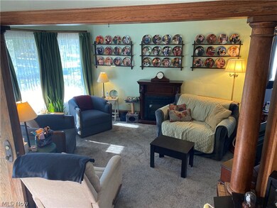 Living room featuring ornate columns and carpet floors