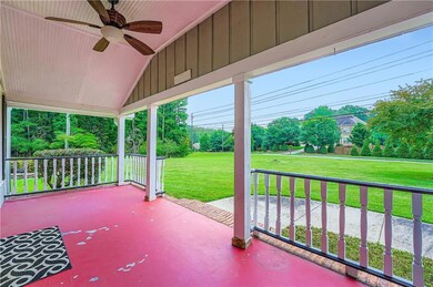 Covered porch with a ceiling fan and a lawn