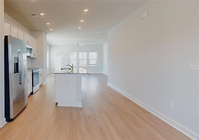 Kitchen with ceiling fan, a center island with sin