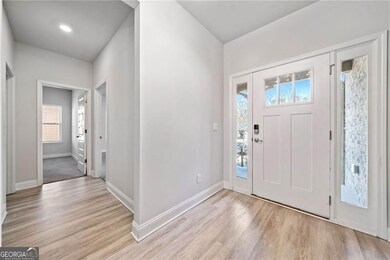 Foyer entrance with light wood-style flooring and baseboards