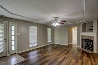 Unfurnished living room featuring dark hardwood / wood-style floors, a tile fireplace, and ceiling fan