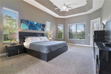 Master bedroom with tray ceiling and access to the