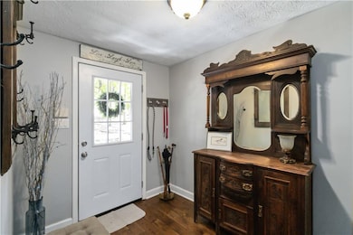 Foyer entrance with dark wood-type flooring and baseboards