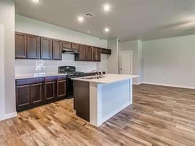 Kitchen with stove, a kitchen island with sink, si