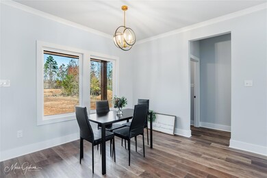 Dining room with a chandelier, dark hardwood / woo