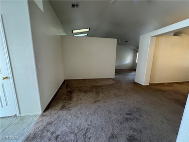 Spare room featuring lofted ceiling, baseboards, v