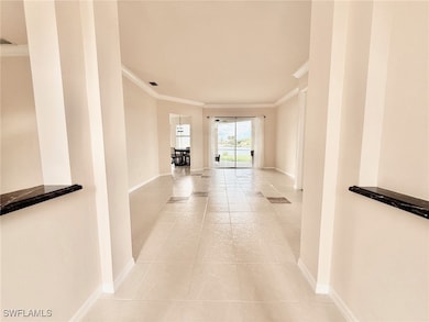 Corridor featuring ornamental molding and light tile patterned floors