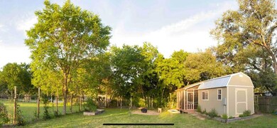 View of yard featuring a sunroom, a garden, and a