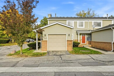 Traditional-style home featuring a chimney, brick siding, and asphalt driveway