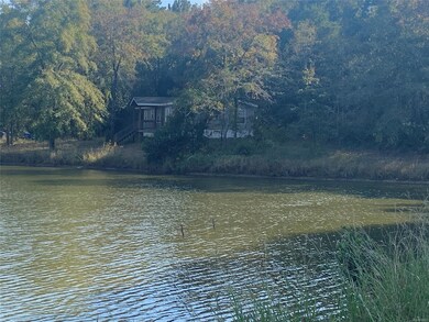 Overlooking pond with mobile home in background.