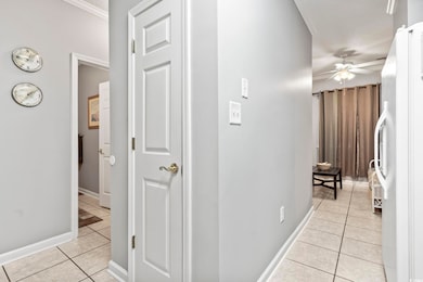 Corridor featuring light tile patterned floors, ba