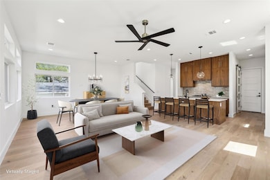 Living area featuring visible vents, light wood f