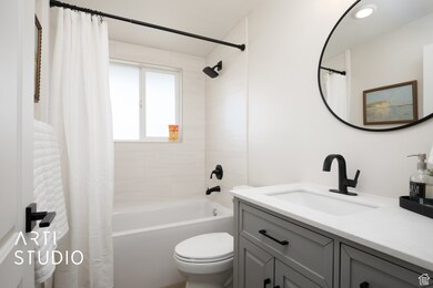 Bathroom with shower / tub combo with curtain and vanity