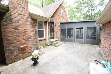 View of patio featuring a sunroom