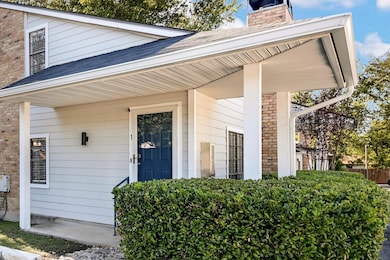 Doorway to property featuring a chimney, roof with shingles, and brick siding