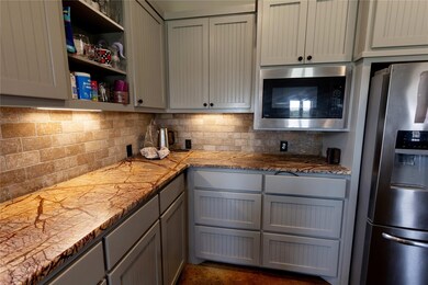 Kitchen with backsplash, stainless steel fridge, b
