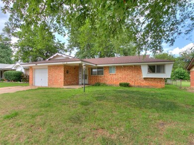 Single story home with a garage and a front yard