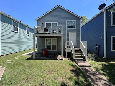 Rear view of property featuring a lawn and a balc