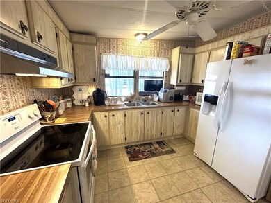 Kitchen featuring white appliances, a ceiling fan,