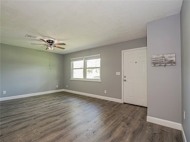 Entryway with a textured ceiling, dark wood-style flooring, and ceiling fan